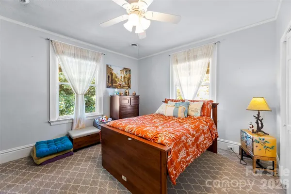 a bedroom with a large bed and a chandelier