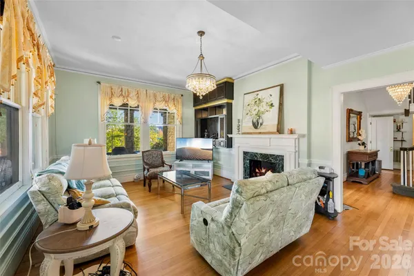 a living room with furniture fireplace and a large window