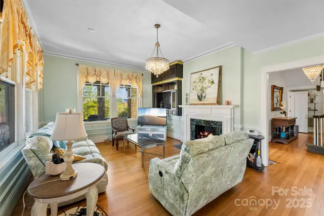 a living room with furniture fireplace and a large window