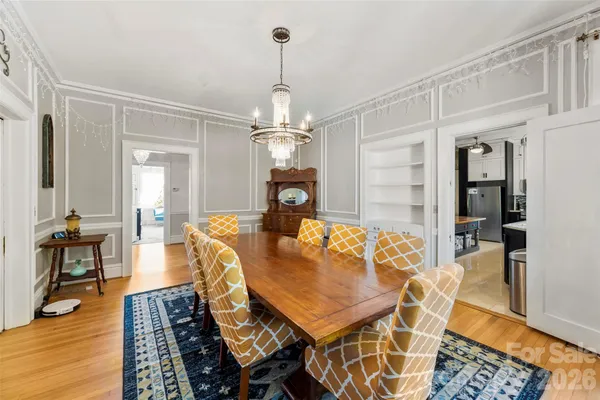a living room with furniture a dining table and a chandelier