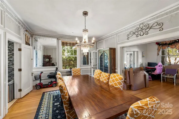 a living room with furniture dining table and a chandelier