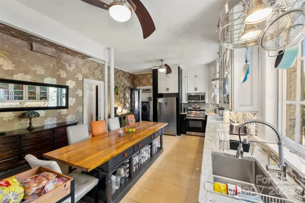 a large kitchen with a table chairs and refrigerator