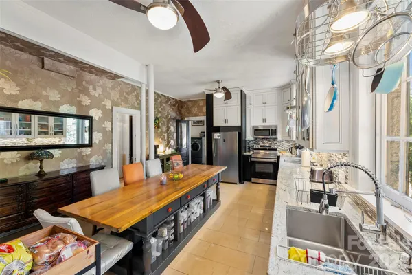 a large kitchen with a table chairs refrigerator and a stove