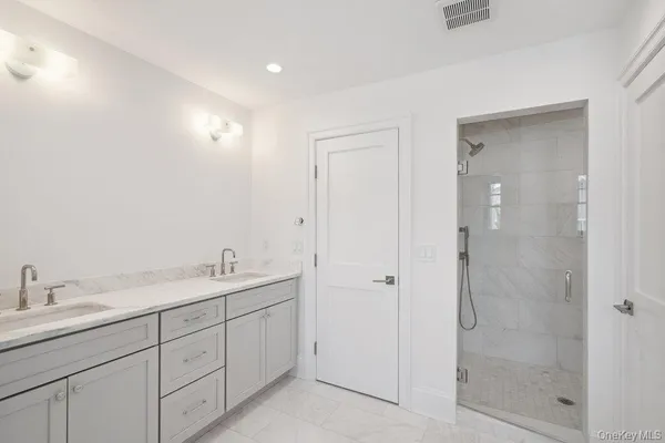 a spacious bathroom with a shower sink and mirror