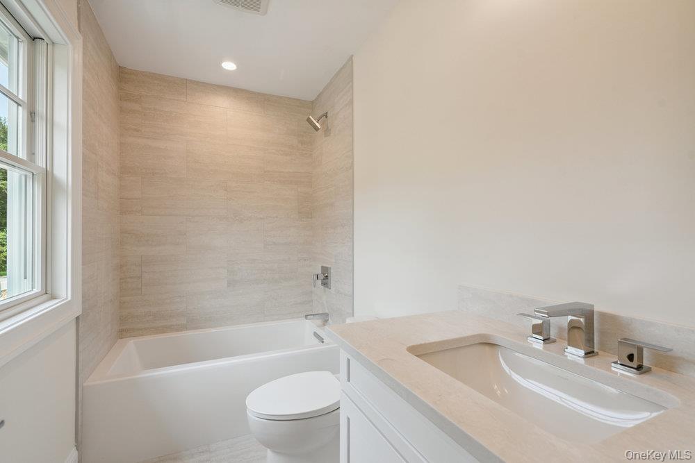 46 Plainview Road Woodbury, NY 11797 - Photo 34 of 46 a bathroom with a bathtub shower sink vanity mirror and toilet