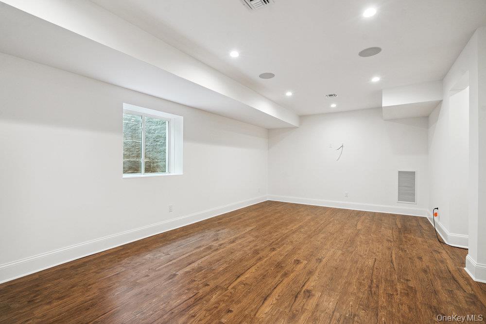 46 Plainview Road Woodbury, NY 11797 - Photo 36 of 46 an empty room with wooden floor and windows