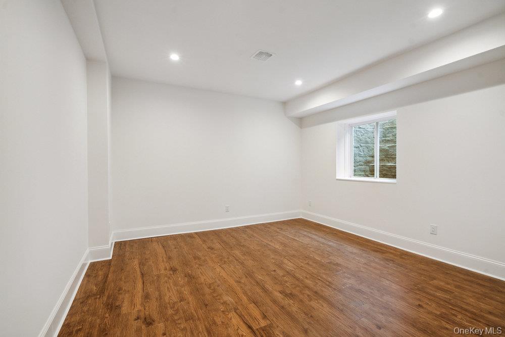 46 Plainview Road Woodbury, NY 11797 - Photo 37 of 46 an empty room with wooden floor and windows