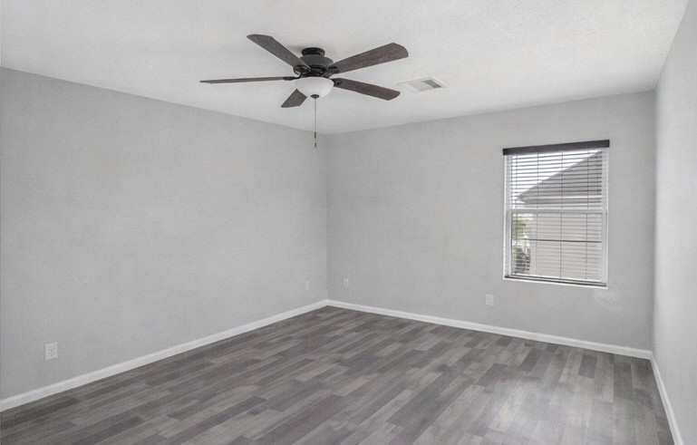 1726 Sun Point Court Humble, TX 77396 - Photo 14 of 26 an empty room with wooden floor ceiling fan and windows