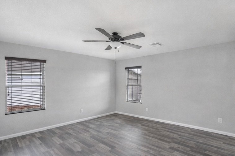 1726 Sun Point Court Humble, TX 77396 - Photo 15 of 26 an empty room with wooden floor chandelier fan and windows