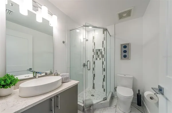 a bathroom with a granite countertop sink toilet and shower