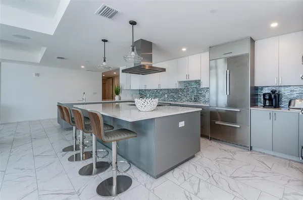 a kitchen with a sink a counter space appliances and cabinets