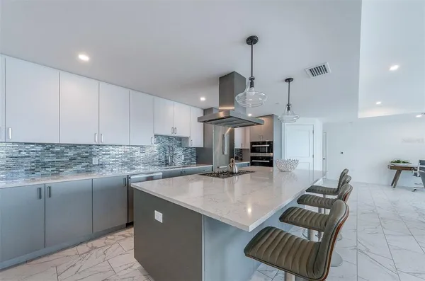 a kitchen with stainless steel appliances granite countertop a sink a stove and a counter top space