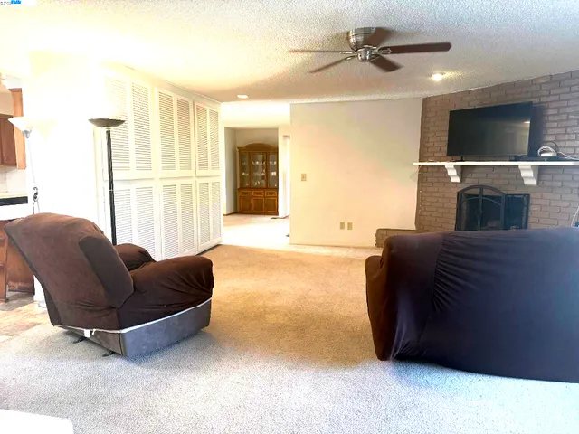 a living room with furniture a ceiling fan and a rug