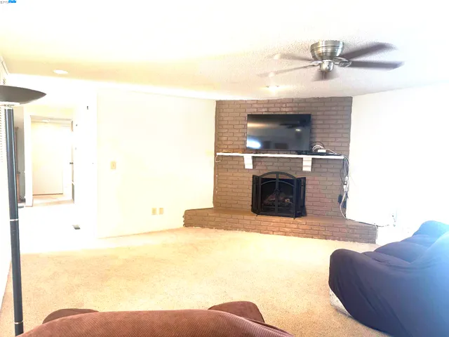 a living room with a fireplace and a ceiling fan