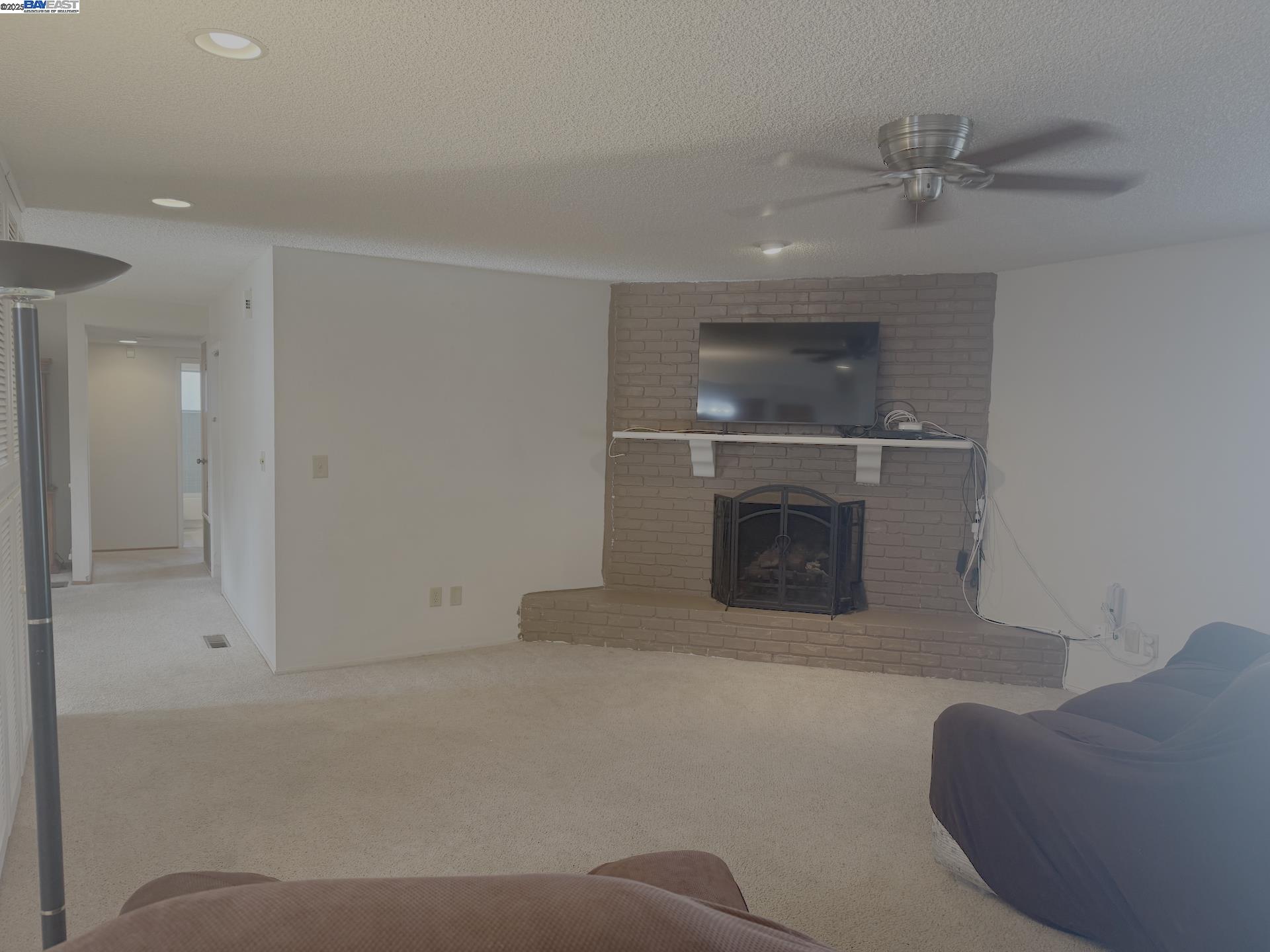 701 North 3rd Street Patterson, CA 95363 - Photo 18 of 23 a living room with a fireplace and a ceiling fan