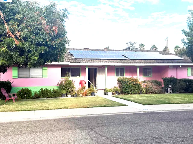 a front view of a house with a yard and potted plants