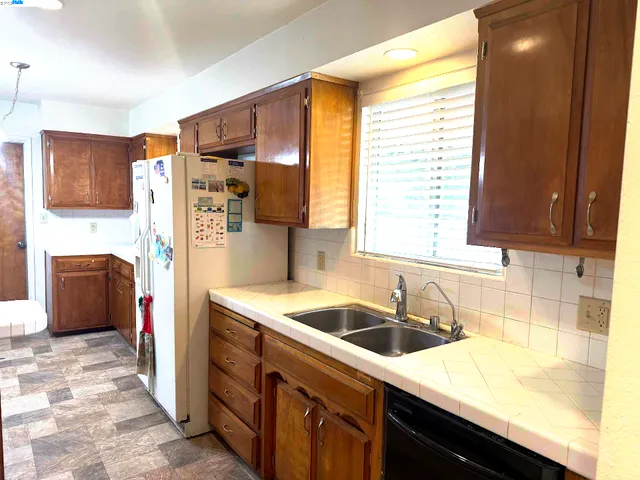 a kitchen that has a sink a stove and refrigerator