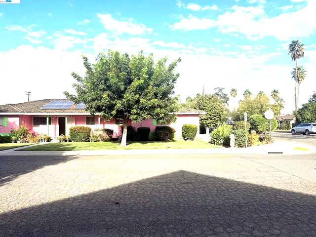 a front view of a house with a yard and trees