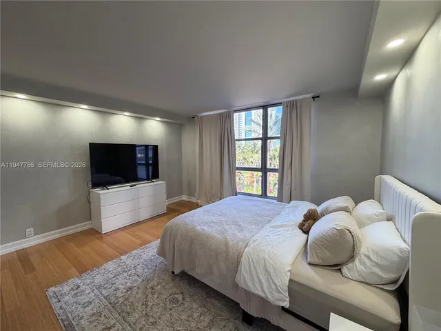 a bedroom with a bed and a flat screen tv
