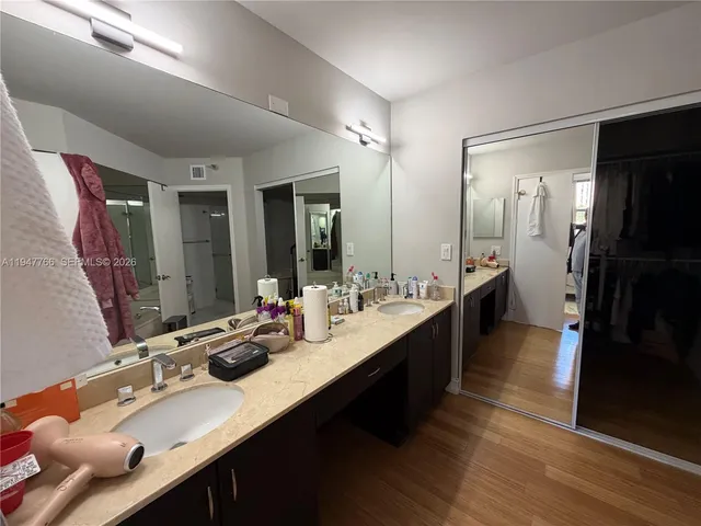 a large bathroom with a double vanity sink a large mirror and shower