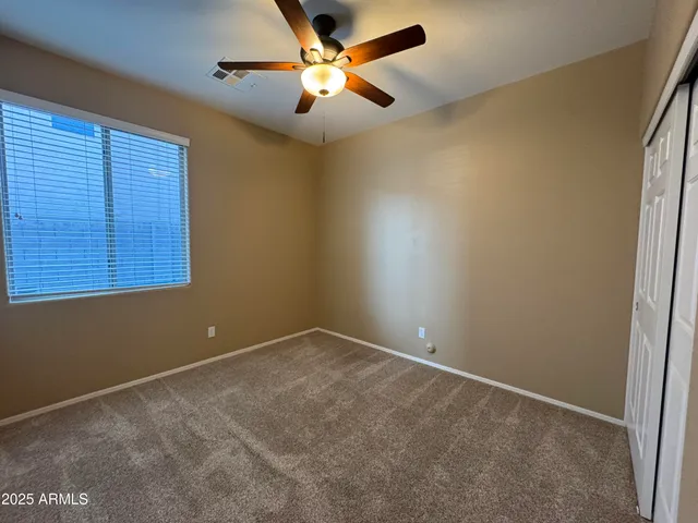 an empty room with a window and a fan