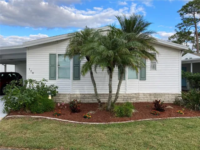 a front view of a house with a yard and potted plants