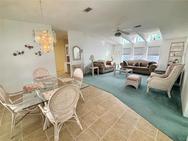 a living room with furniture a chandelier and a fireplace