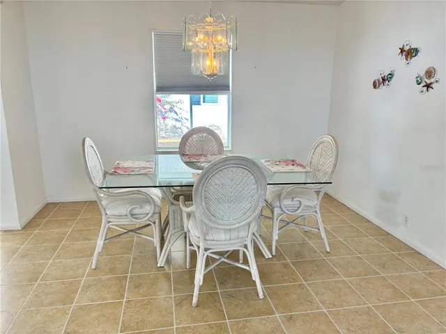 a dining room with chandelier fan and wooden floor