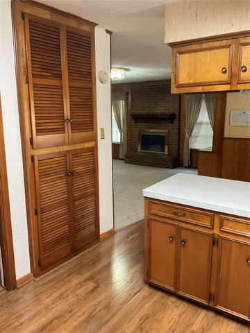 an empty room with wooden floor and fireplace