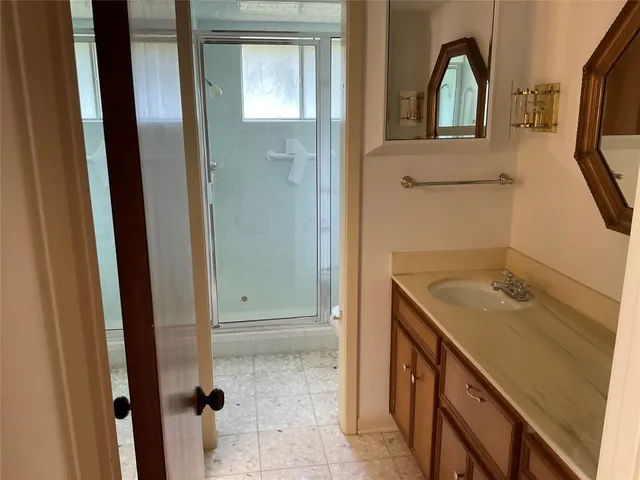 a view of bathroom with a sink mirror and window