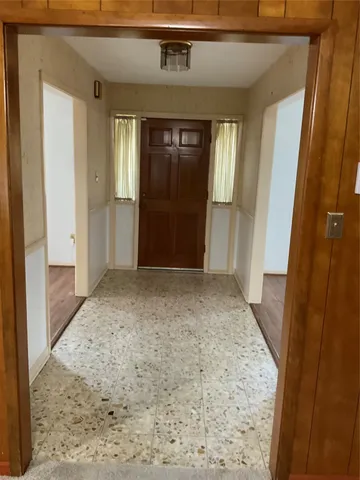 view of a hallway with wooden walls and entryway