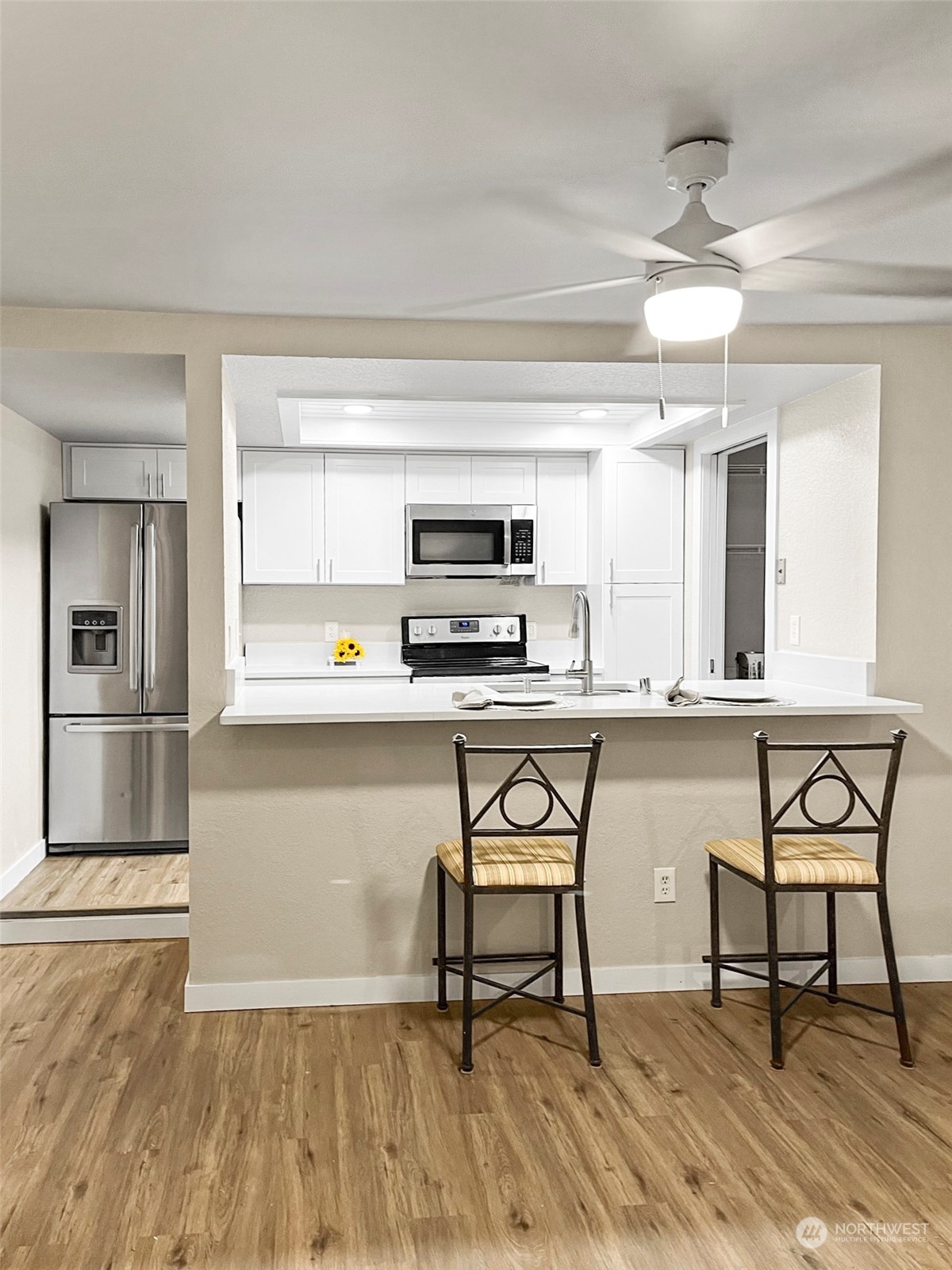 14401 Southeast Petrovitsky Road, Unit C103 Renton, WA 98058 - Photo 4 of 29 a kitchen with stainless steel appliances kitchen island granite countertop a stove a sink and a microwave