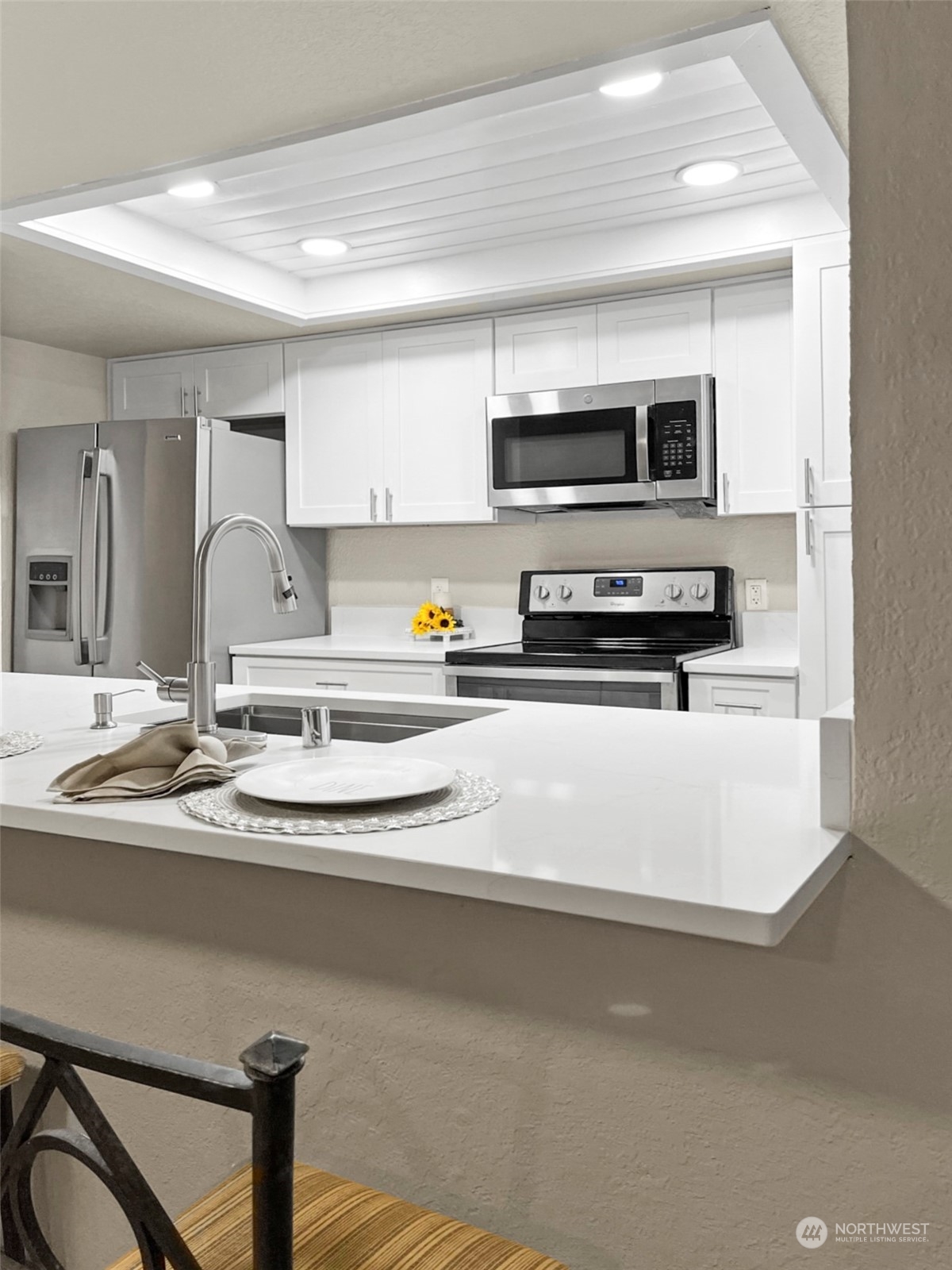 14401 Southeast Petrovitsky Road, Unit C103 Renton, WA 98058 - Photo 5 of 29 a kitchen with stainless steel appliances a sink a stove a microwave a sink a refrigerator and cabinets