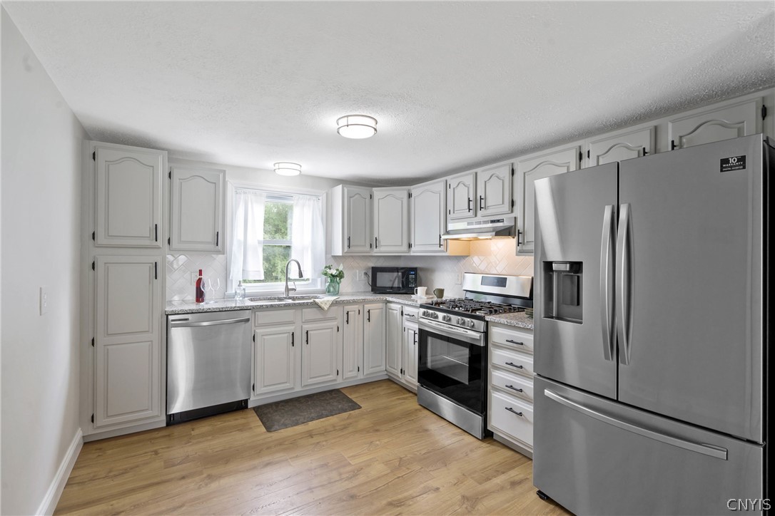 6130 South Bay Road Cicero, NY 13039 - Photo 10 of 30 The sleek stainless steel appliances of the kitchen are complemented by the ice gray hue of the cabinets. Wide plank vinyl flooring underfoot sparkles and is so easy to keep clean.