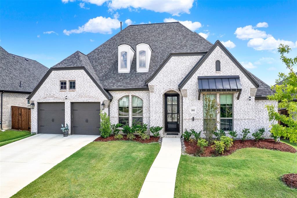 a view of a house with brick walls and a yard with plants
