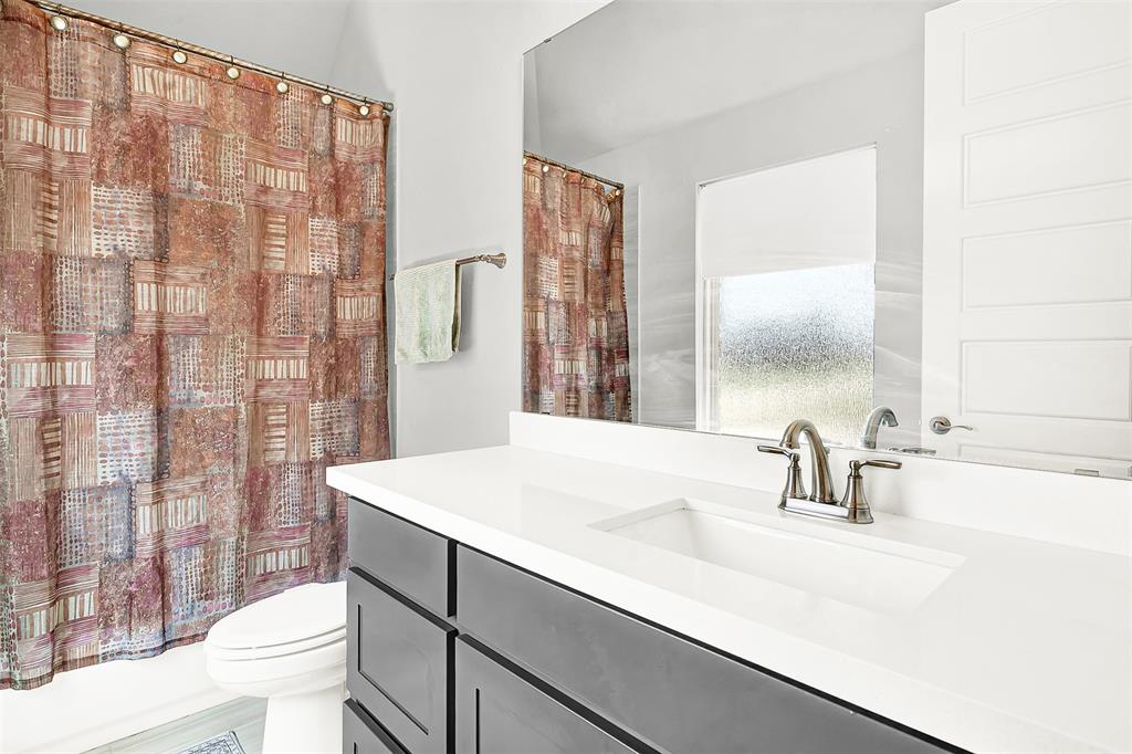 1004 Open Range Drive Mansfield, TX 76063 - Photo 11 of 40 a bathroom with a sink a toilet and shower curtain