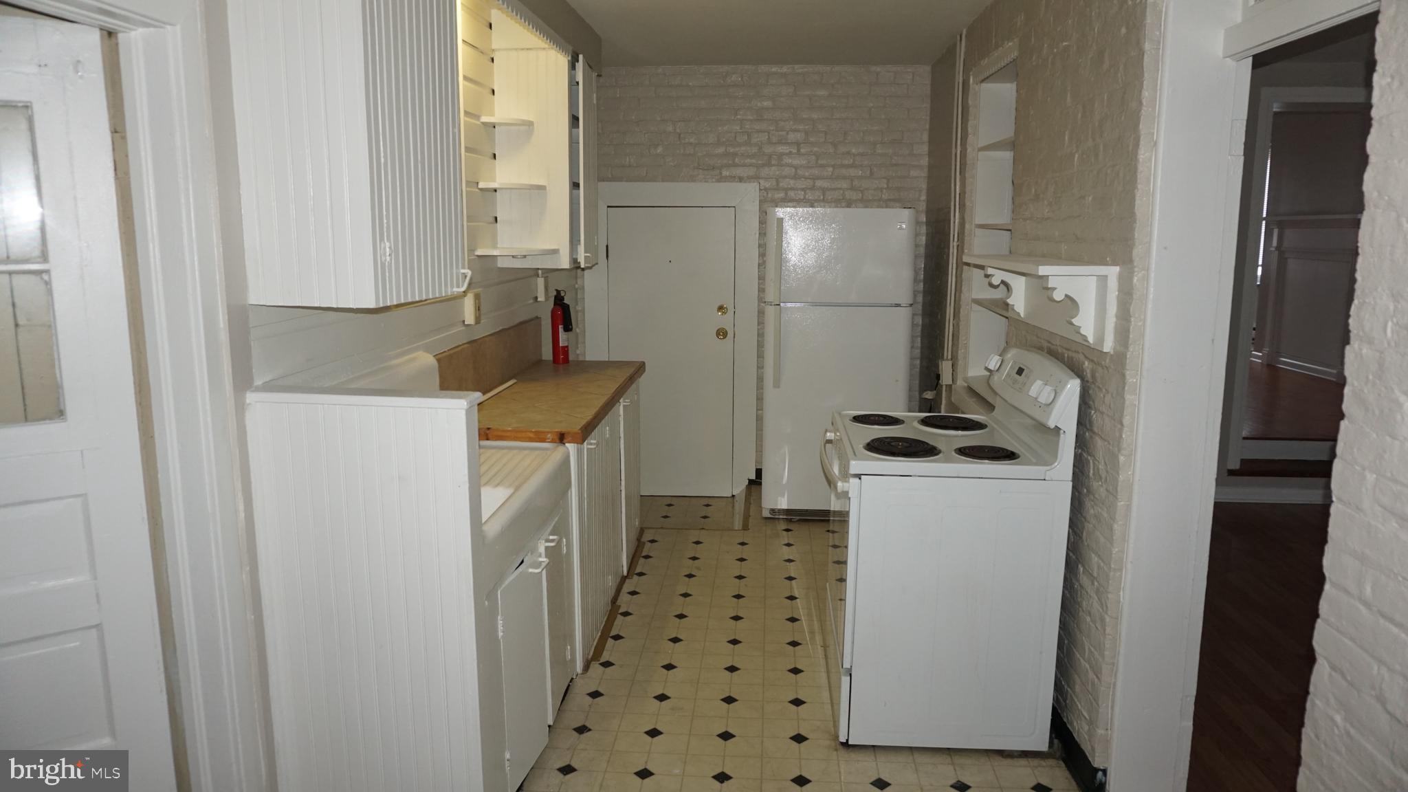276 East Main Street, Unit 4 Westminster, MD 21157 - Photo 6 of 26 a kitchen with a refrigerator a stove and white cabinets