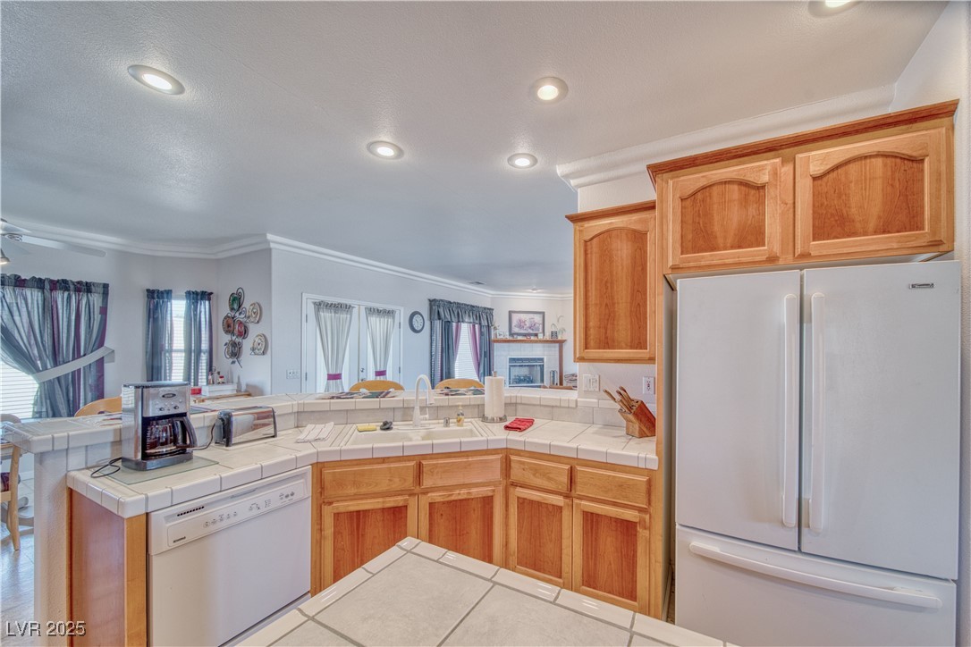 660 Indian Road Pahrump, NV 89048 - Photo 31 of 54 Kitchen with white Kenmore appliances, alder wood cabs, breakfast bar, island, crown moulding, recessed lighting, ceiling fan, and sink.