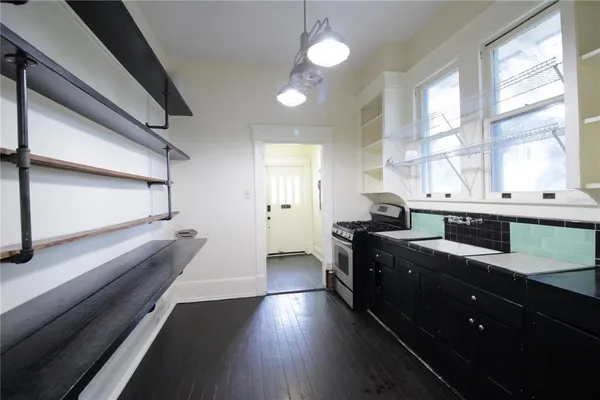 a kitchen with stainless steel appliances sink a stove and a window