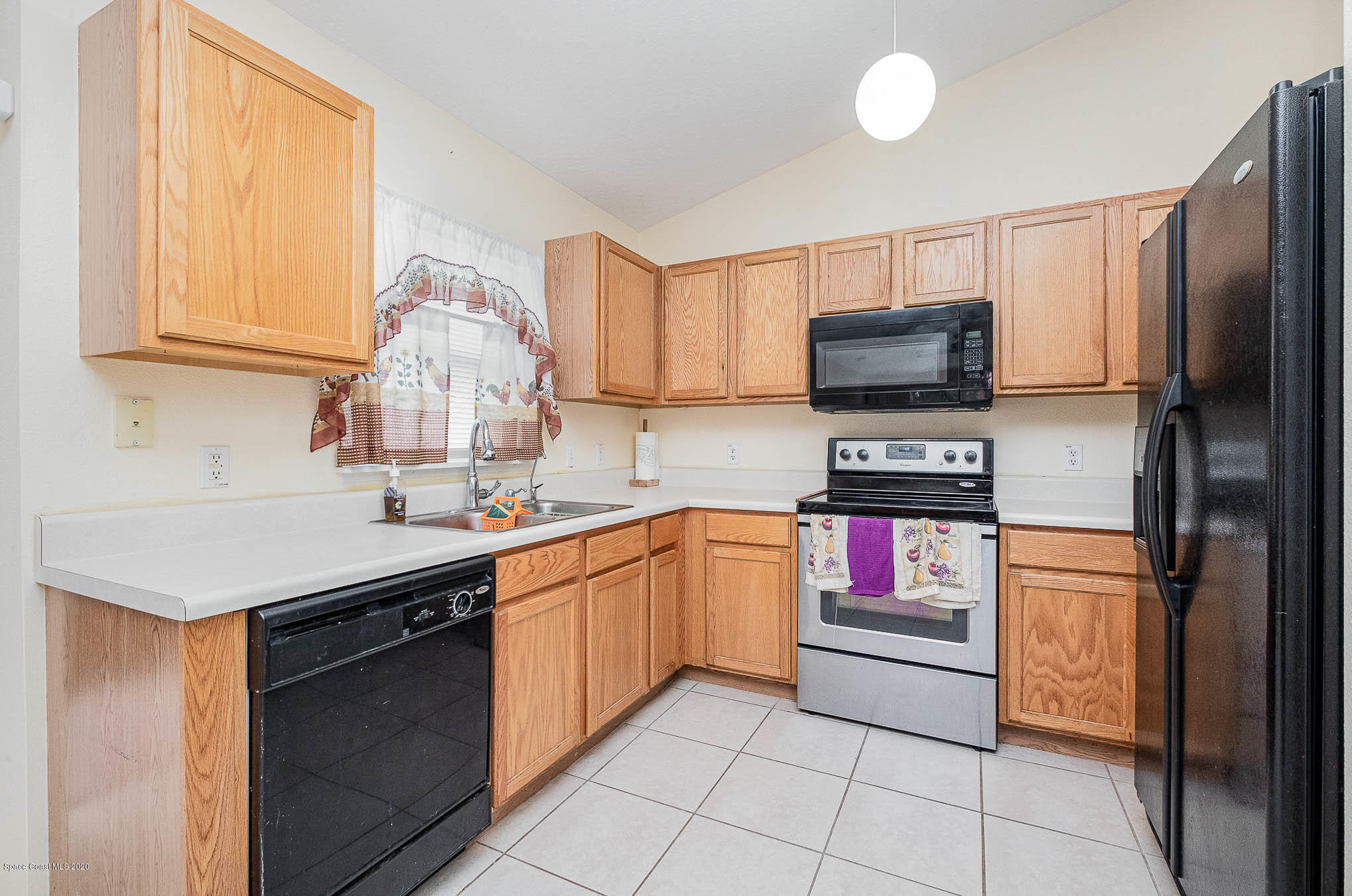 498 Scarlet Road Southwest Palm Bay, FL 32908 - Photo 12 of 24 a kitchen with stainless steel appliances granite countertop a sink and a refrigerator