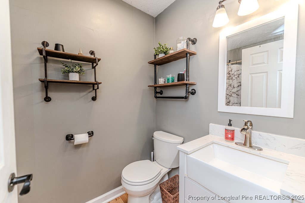 476 Riddle Road Sanford, NC 27330 - Photo 15 of 34 a bathroom with a sink vanity mirror and toilet