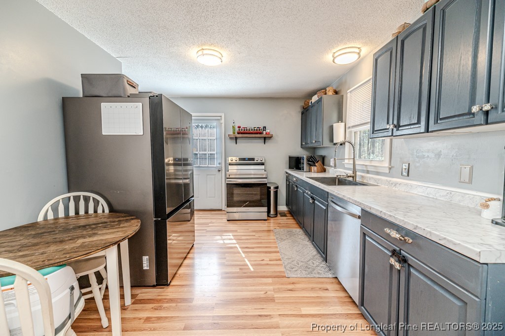 476 Riddle Road Sanford, NC 27330 - Photo 8 of 34 a kitchen with stainless steel appliances granite countertop a refrigerator a stove and a sink