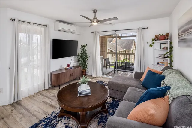 a living room with furniture a flat screen tv and a large window