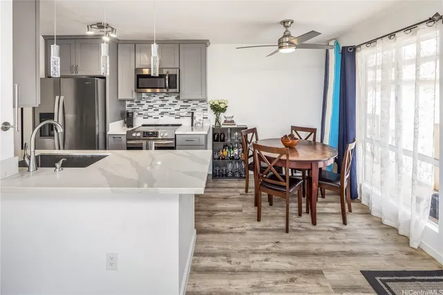 a living room with stainless steel appliances kitchen island granite countertop furniture and a fireplace