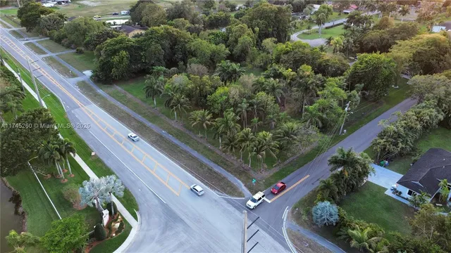 an aerial view of residential houses with outdoor space and trees