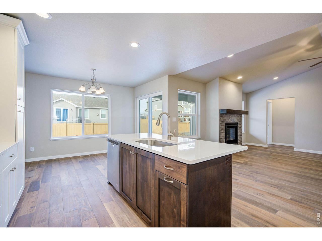 7040 Feather Reed Drive Wellington, CO 80549 - Photo 13 of 32 a view of kitchen island a sink wooden floor and a living room