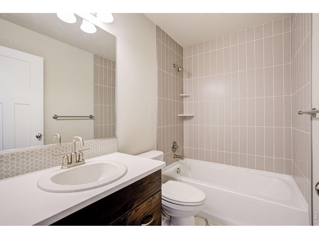 7040 Feather Reed Drive Wellington, CO 80549 - Photo 25 of 32 a bathroom with a sink a toilet a shower a mirror and a bathtub