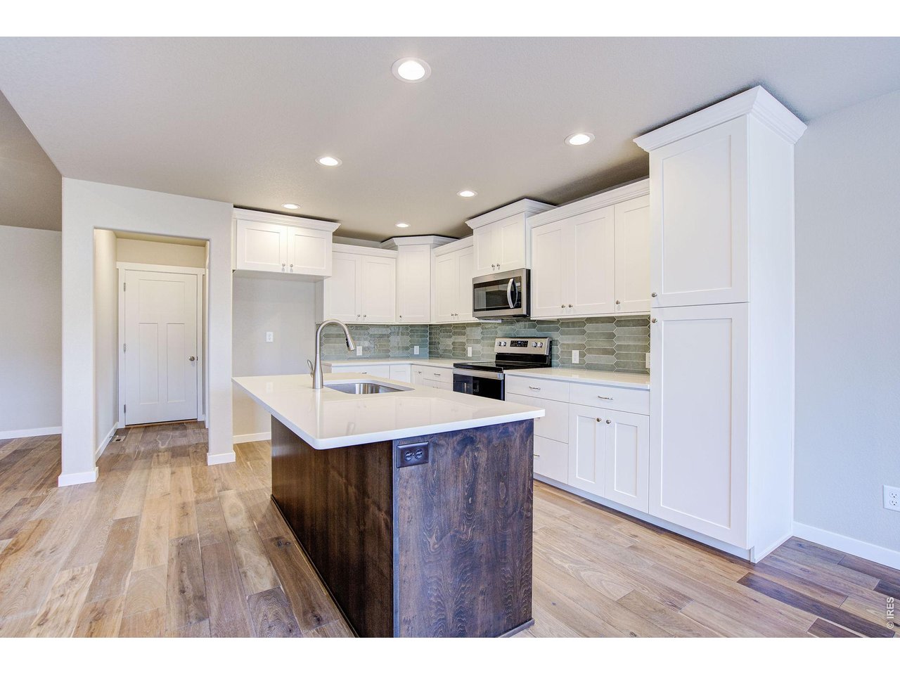 7040 Feather Reed Drive Wellington, CO 80549 - Photo 10 of 32 a kitchen with a sink a refrigerator and wooden floor