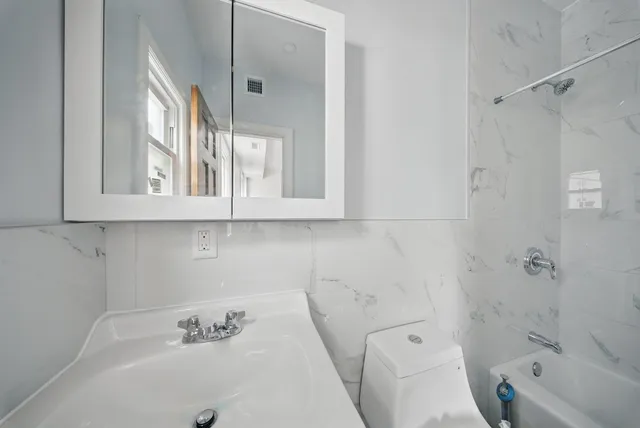 a bathroom with a sink a toilet and bathtub