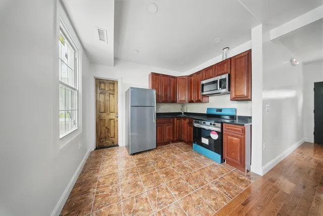 a kitchen with stainless steel appliances granite countertop a refrigerator and a stove top oven